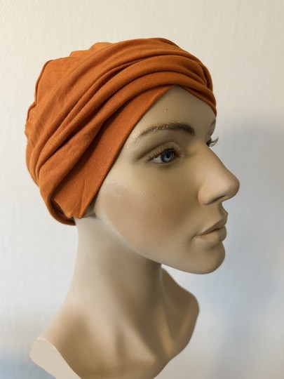 Smuk enkelt turban fra Gisela Mayer. Huen er helt tynd og sommer venlig. De fine læg i fronten giver den lidt fylde og struktur, og syningen på toppen af hovedet giver flot fylde på baghovedet.